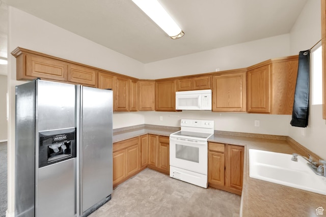kitchen featuring white appliances, light countertops, and a sink