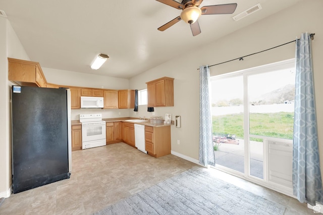 kitchen featuring light brown cabinets, visible vents, white appliances, and plenty of natural light