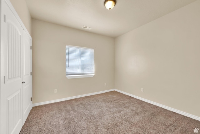 unfurnished bedroom featuring a closet, carpet flooring, baseboards, and visible vents