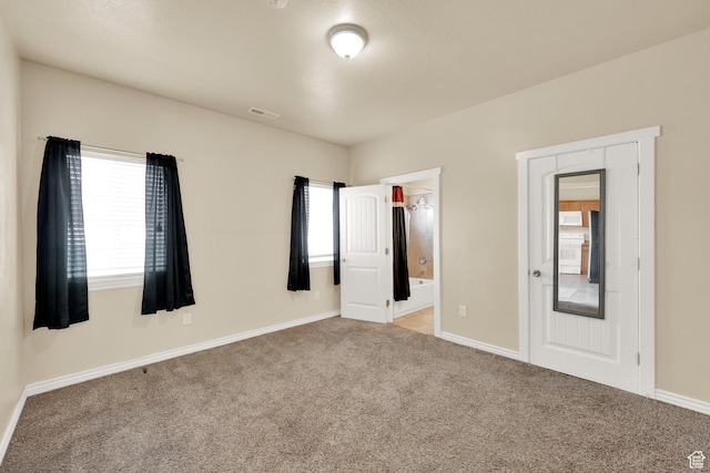 unfurnished bedroom with baseboards, visible vents, carpet floors, and connected bathroom