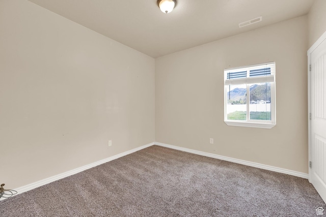unfurnished room featuring carpet, visible vents, and baseboards