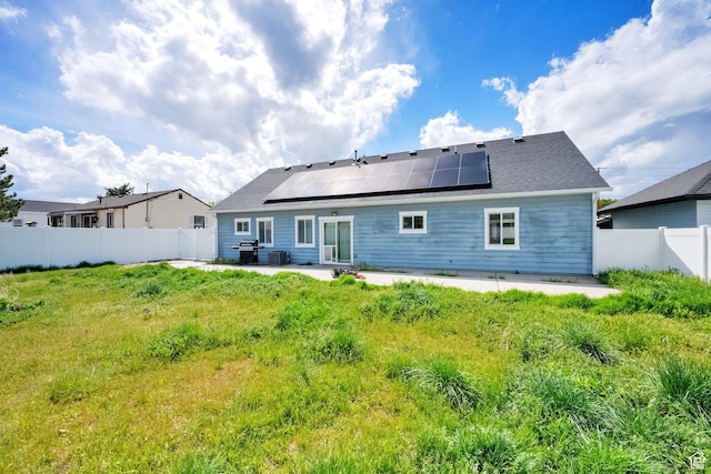 back of property with a patio, solar panels, and a fenced backyard