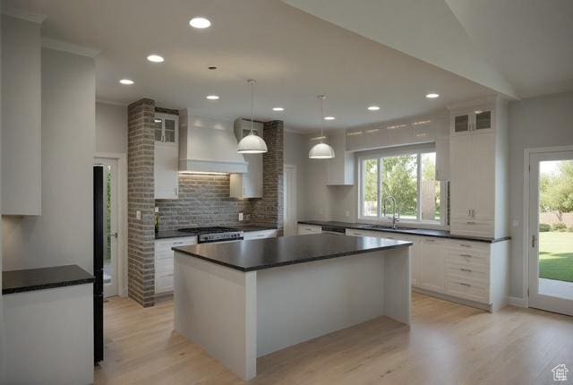 kitchen with dark countertops, decorative backsplash, white cabinets, and a sink