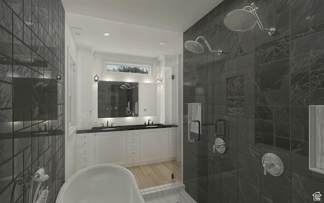 bathroom with double vanity, tile walls, a stall shower, and a sink