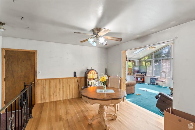 sitting room featuring ceiling fan, wainscoting, wood walls, and wood finished floors