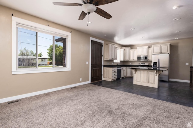 167 E 300 S, Salina, UT 84654 - kitchen with appliances with stainless steel finishes, baseboards, a kitchen bar, dark countertops, and a ceiling fan