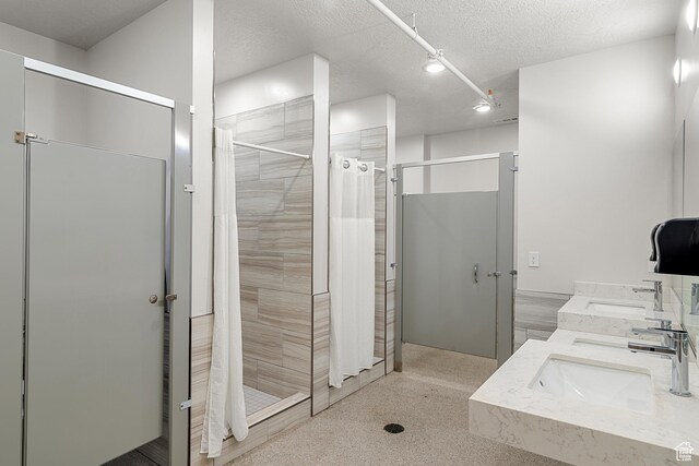140 W 150 S Unit H29, Garden City, UT 84028 - full bath featuring double vanity, a textured ceiling, a shower stall, and a sink