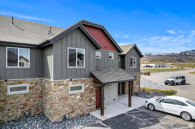 140 W 150 S Unit H29, Garden City, UT 84028 - craftsman-style home featuring uncovered parking, a shingled roof, a mountain view, stone siding, and board and batten siding