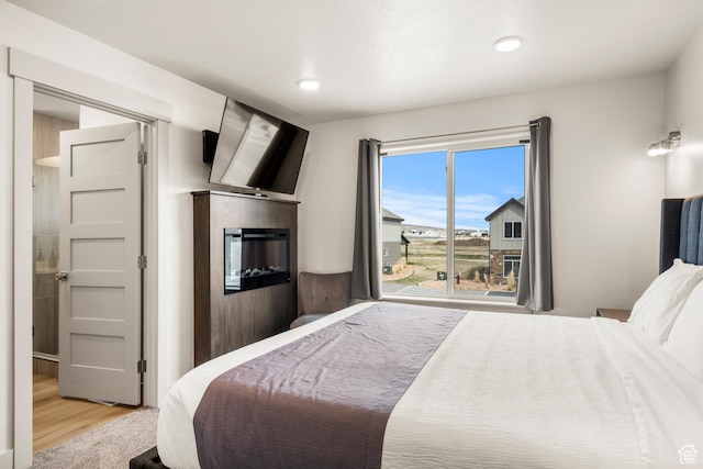 140 W 150 S Unit H29, Garden City, UT 84028 - bedroom featuring recessed lighting, wood finished floors, and a glass covered fireplace