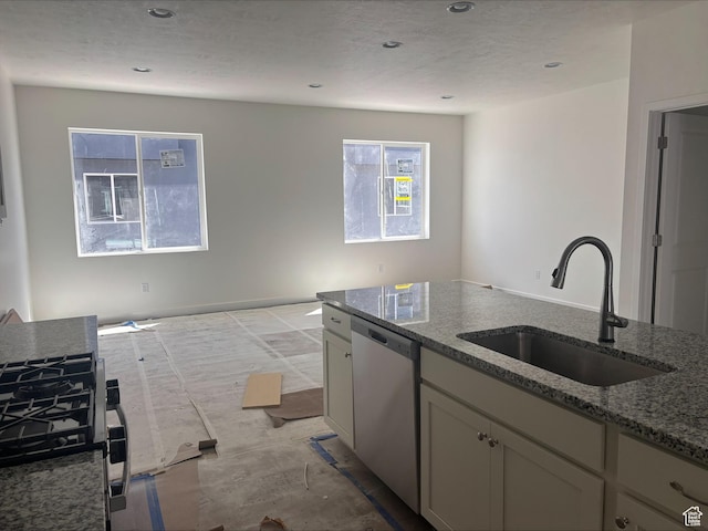 kitchen featuring a textured ceiling, stainless steel dishwasher, a sink, stone counters, and recessed lighting