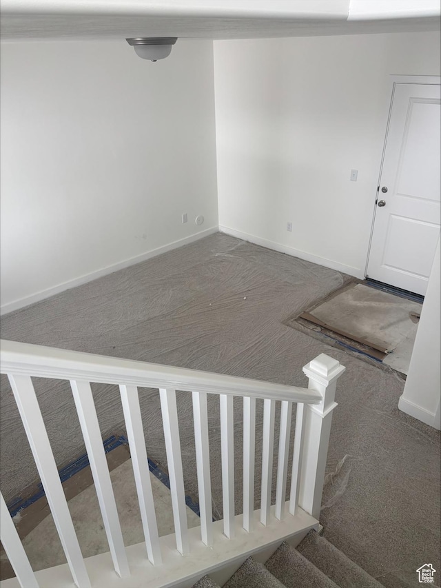 stairway featuring carpet floors and baseboards
