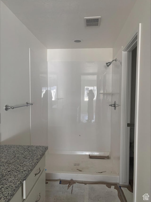 bathroom with visible vents, a stall shower, and vanity