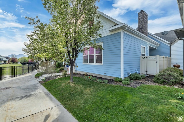 4352 W Degray Dr S, South Jordan, UT 84009 - view of side of home featuring a chimney, fence, a gate, and a yard