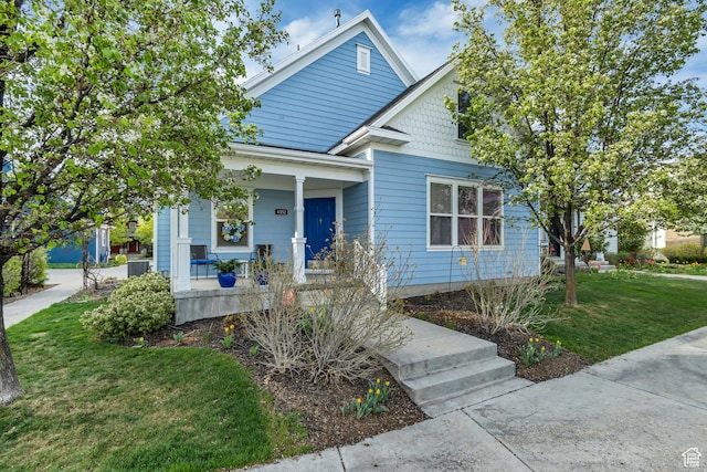 bungalow-style home featuring covered porch and a front lawn
