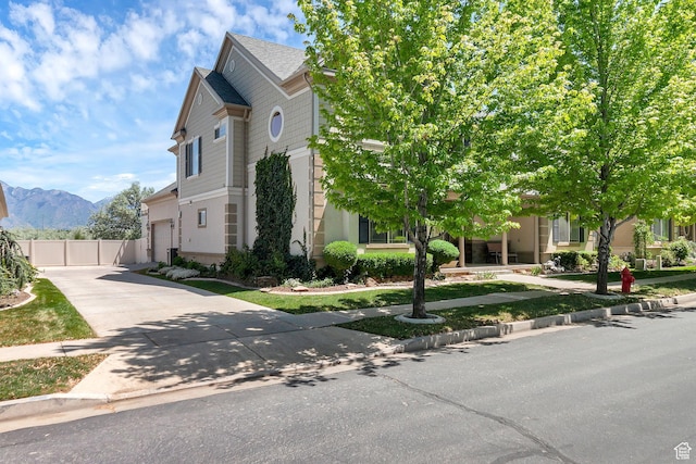 6861 S Triumph Ln, West Jordan, UT 84084 - view of front of home with concrete driveway, a mountain view, fence, and a garage