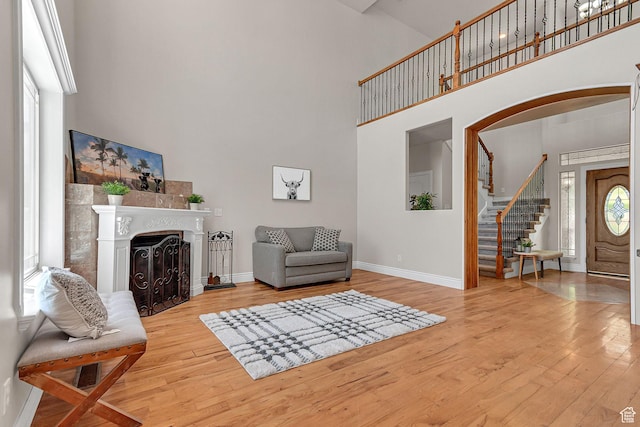 6861 S Triumph Ln, West Jordan, UT 84084 - sitting room featuring a high ceiling, wood finished floors, baseboards, a fireplace, and stairs
