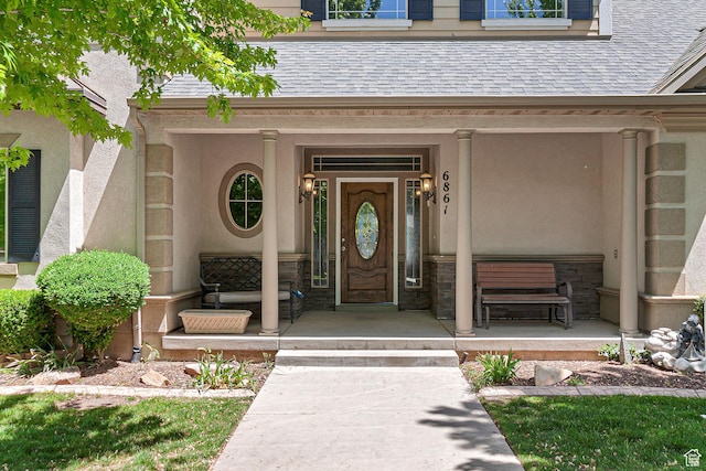 6861 S Triumph Ln, West Jordan, UT 84084 - property entrance with a porch, stucco siding, a shingled roof, and stone siding