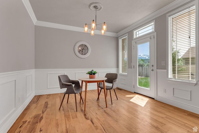 6861 S Triumph Ln, West Jordan, UT 84084 - dining area featuring crown molding, wainscoting, light wood finished floors, and a chandelier