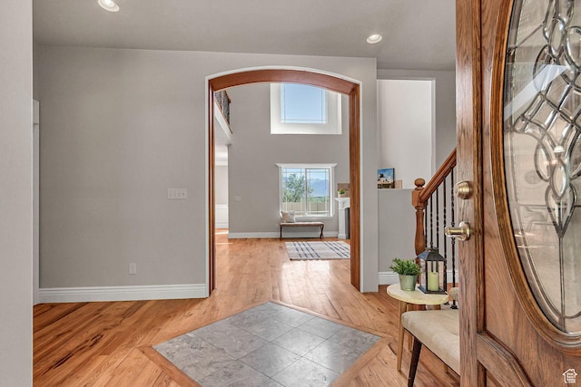 6861 S Triumph Ln, West Jordan, UT 84084 - foyer with arched walkways, light wood finished floors, baseboards, stairs, and recessed lighting