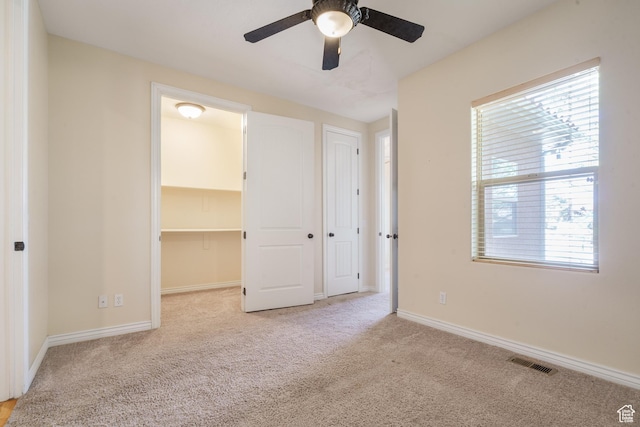 1059 S Ridge Rd, Cedar City, UT 84720 - unfurnished bedroom featuring carpet flooring, ceiling fan, a walk in closet, visible vents, and baseboards