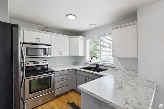 799 Country Club Dr, Stansbury Park, UT 84074 - kitchen with gray cabinets, appliances with stainless steel finishes, light countertops, a sink, and a peninsula