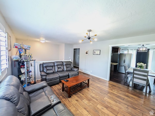 4635 W Eskesen Dr S, West Valley City, UT 84120 - living area with a chandelier, visible vents, light wood-style flooring, baseboards, and a textured ceiling