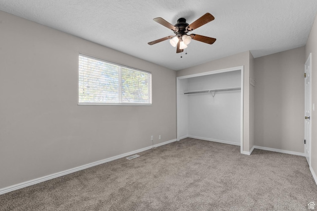 unfurnished bedroom featuring a closet, a textured ceiling, carpet floors, and baseboards