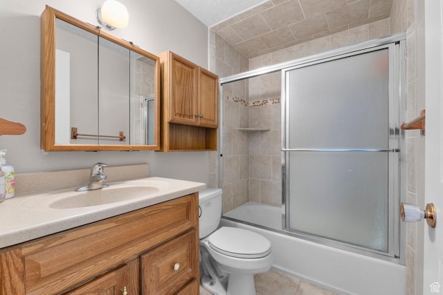 bathroom with tile patterned floors, toilet, enclosed tub / shower combo, and vanity