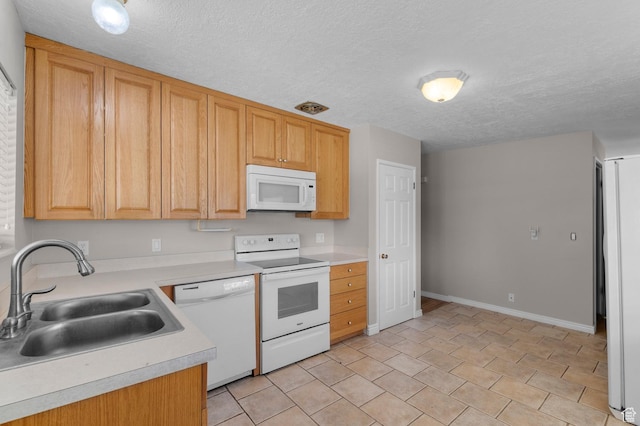 kitchen featuring a textured ceiling, a sink, light countertops, baseboards, and white appliances