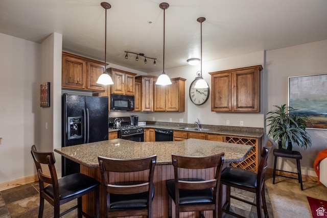 5519 N Lillehammer Ln Unit 1201, Park City, UT 84098 - kitchen with brown cabinetry, decorative light fixtures, black appliances, a sink, and baseboards