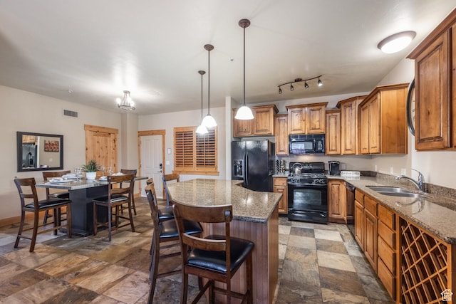 5519 N Lillehammer Ln Unit 1201, Park City, UT 84098 - kitchen featuring a sink, brown cabinetry, stone finish flooring, a center island, and black appliances