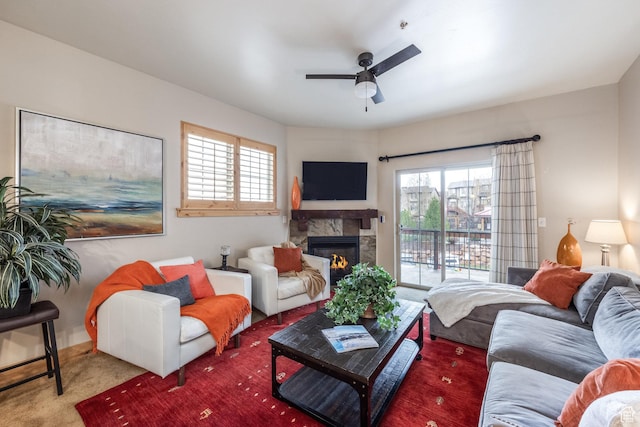 carpeted living area featuring ceiling fan and a glass covered fireplace