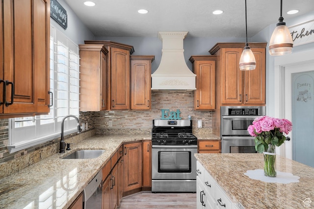 2277 W 900 N, Lehi, UT 84043 - kitchen featuring light stone counters, brown cabinetry, custom range hood, appliances with stainless steel finishes, and a sink
