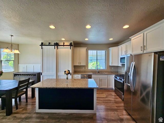 1013 W 90 S, Spanish Fork, UT 84660 - kitchen with stainless steel appliances, a sink, a kitchen island, white cabinets, and recessed lighting