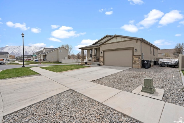 1013 W 90 S, Spanish Fork, UT 84660 - view of front facade with a garage, concrete driveway, stone siding, a front lawn, and a residential view