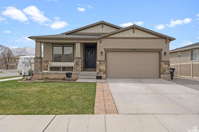 1013 W 90 S, Spanish Fork, UT 84660 - view of front of house featuring stone siding, a front lawn, an attached garage, driveway, and board and batten siding