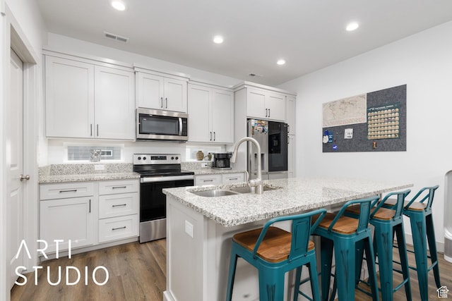 442 E Depot St Unit 107, Clearfield, UT 84015 - kitchen with dark wood-style floors, a sink, a kitchen bar, visible vents, and appliances with stainless steel finishes