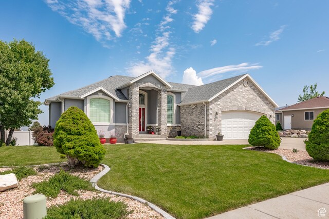 ranch-style home featuring a front yard, a garage, roof with shingles, concrete driveway, and stucco siding