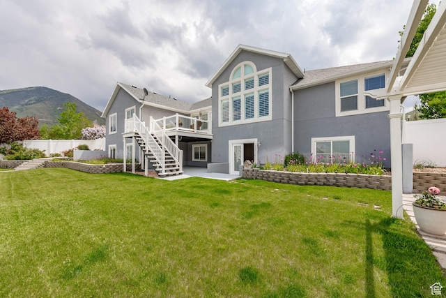 1307 E Brandy Ln S, Tooele, UT 84074 - back of house with a wooden deck, a yard, stairs, stucco siding, and fence