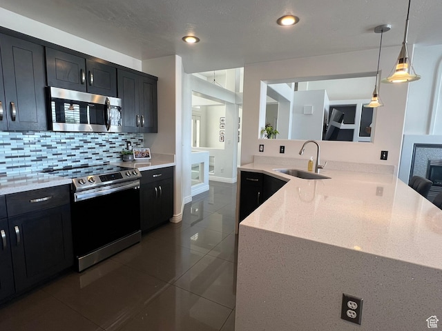 1307 E Brandy Ln S, Tooele, UT 84074 - kitchen featuring appliances with stainless steel finishes, dark tile patterned flooring, dark cabinetry, and a sink
