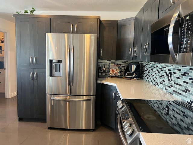 1307 E Brandy Ln S, Tooele, UT 84074 - kitchen with stainless steel appliances, light tile patterned flooring, light countertops, and decorative backsplash