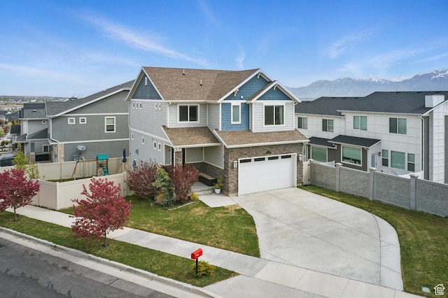 craftsman-style house with a mountain view, driveway, stone siding, an attached garage, and fence