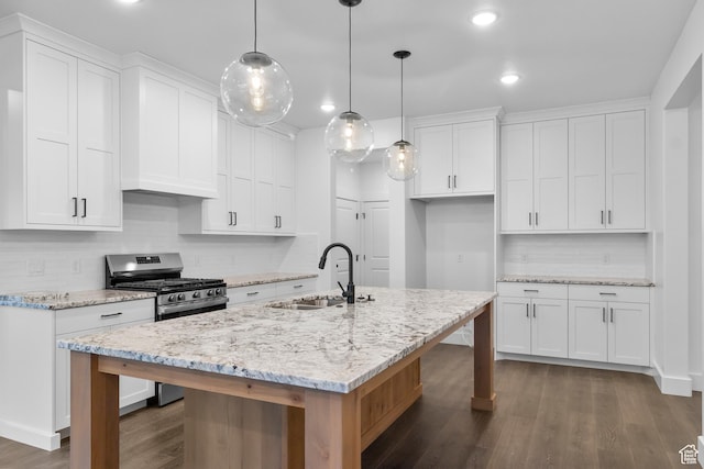 kitchen featuring a sink, tasteful backsplash, stainless steel range with gas stovetop, and dark wood finished floors