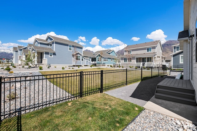 view of community with fence, a residential view, and a lawn