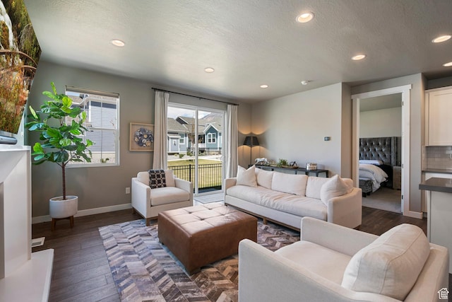 living room featuring dark wood-style flooring, recessed lighting, baseboards, and a textured ceiling