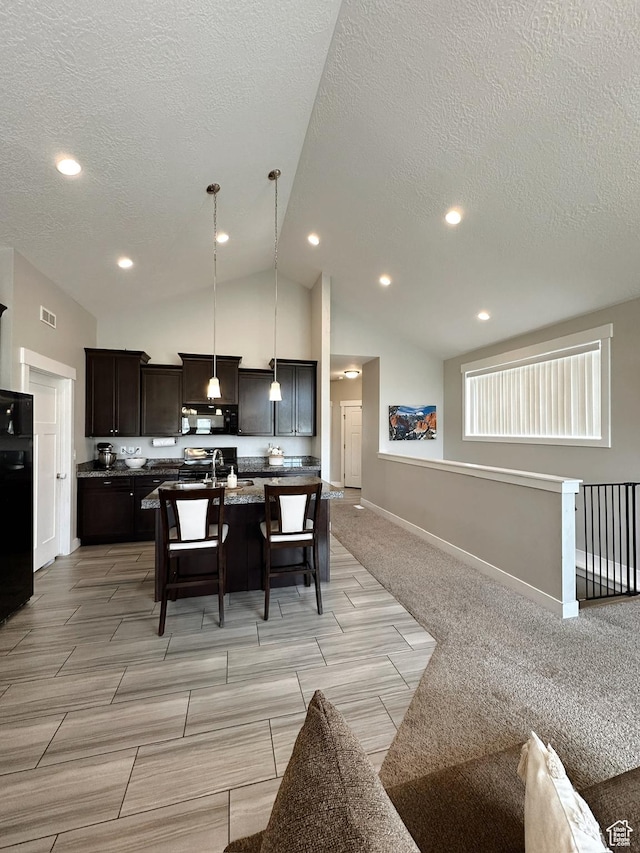 2743 W Lacewood Dr S, Taylorsville, UT 84129 - kitchen featuring black appliances, open floor plan, a kitchen bar, and an island with sink