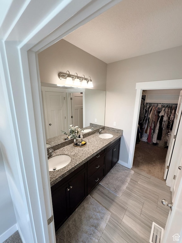 2743 W Lacewood Dr S, Taylorsville, UT 84129 - full bathroom with a sink, a walk in closet, double vanity, visible vents, and baseboards