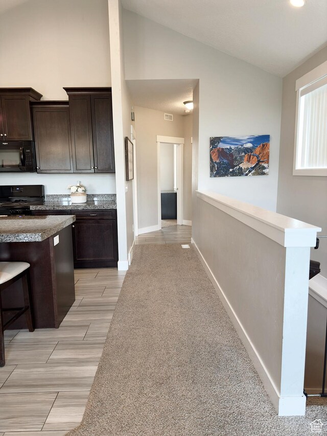 2743 W Lacewood Dr S, Taylorsville, UT 84129 - kitchen with high vaulted ceiling, black appliances, visible vents, baseboards, and dark brown cabinets
