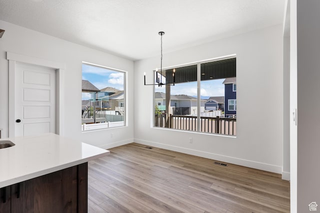 1107 S 4475 W, West Point, UT 84015 - unfurnished dining area featuring wood finished floors and a chandelier