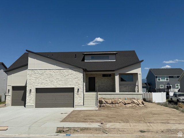 1107 S 4475 W, West Point, UT 84015 - modern home featuring covered porch, stone siding, concrete driveway, and an attached garage